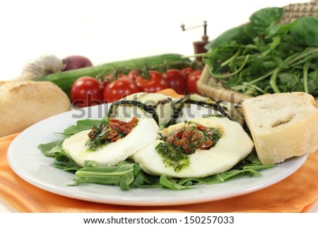 Courgette rolls filled mozzarella and rocket salad on a bed