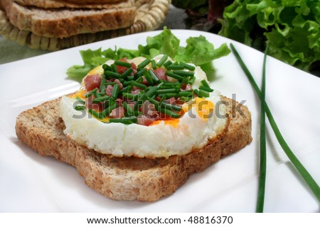 Fried eggs with ham on whole wheat toast and salad