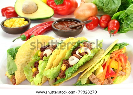 Taco shells filled with ground beef, kidney beans and corn