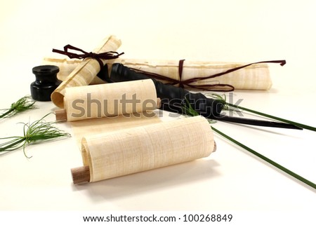 papyrus scrolls with pen, inkwell and papyrus on a light background