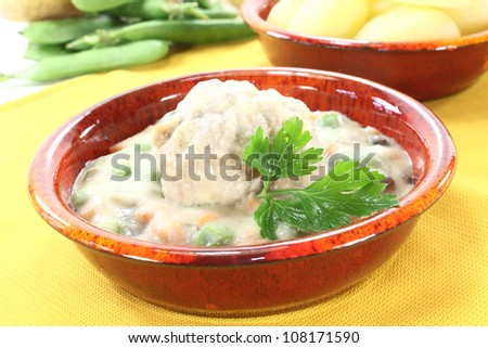 cooked meatballs in a white sauce with capers, garlic and parsley