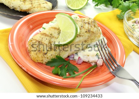 Hake with lemon slice, parsley, chives and potato salad
