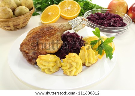 delicious Duck drumstick with duchess potatoes and red cabbage on a bright background