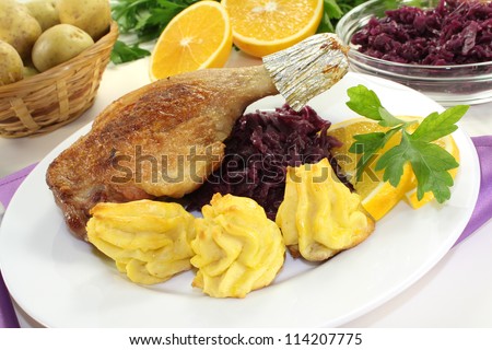 fresh fried Duck drumstick with duchess potatoes and red cabbage on a light background