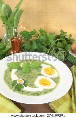 fresh green herbs soup with eggs and a dollop of cream