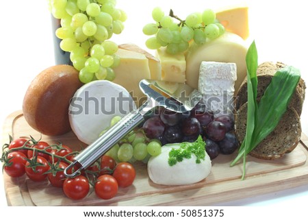 cheeses with fresh grapes and tomatoes and cheese slicer