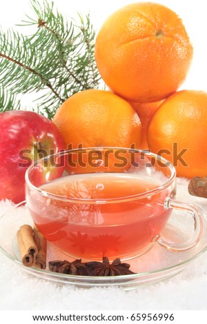 Winter tea with fresh apples and oranges, pine branch and spices in the snow
