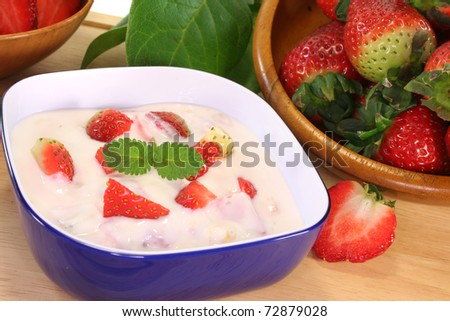 Strawberry yogurt with fresh strawberries on a wooden board
