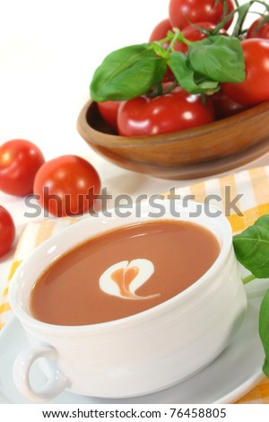 tomato cream soup with dollop of whipped cream and fresh basil