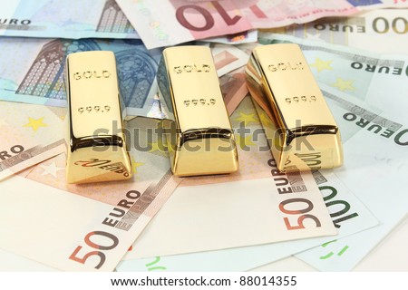 three gold bars on many colorful euro notes