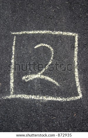 Number two written in chalk on the street.