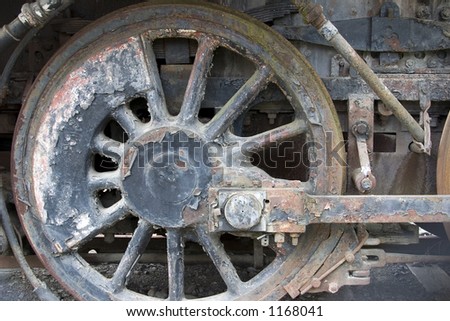 Old driving wheel from a steam locomotive in a state of disrepair in color