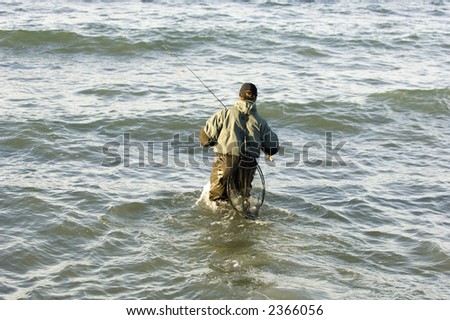 Man walking out in the water do do some fishing