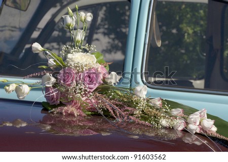 Wedding bouquet with roses laying on a car