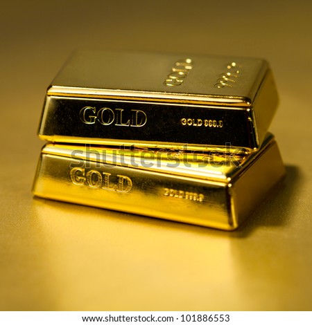 Two Gold bullions on golden background