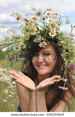 Portrait of the beautiful girl in a natural environment in diadem of wildflowers