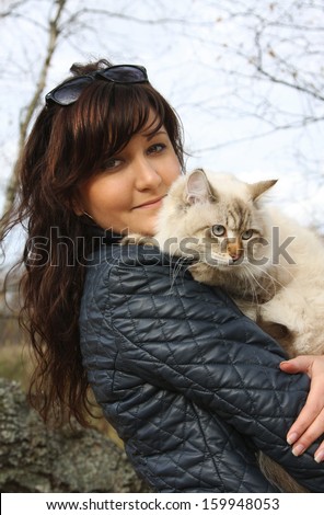 Siberian cat and young woman in a autumn forest