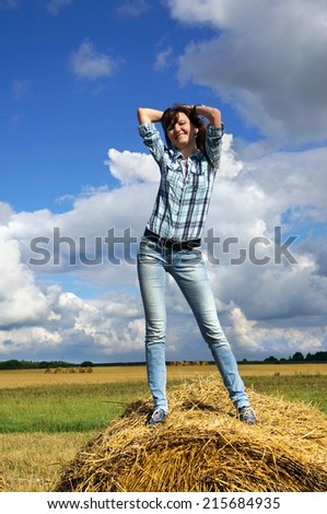 Autumnal nature; Happy woman in haystacks on fields