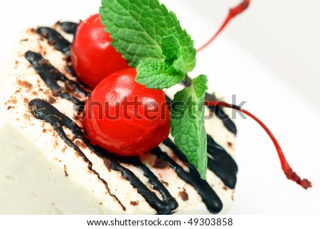 Tasty  celebratory fancy cake with cherry  and green mint