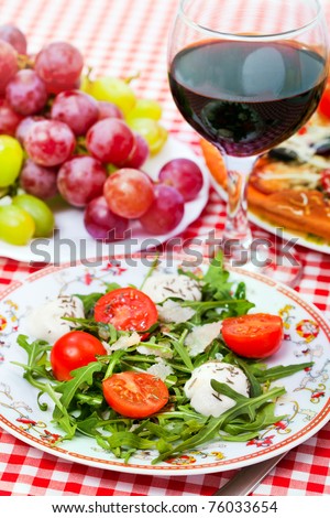 Italian  dinner - salad, pizza and vine on a table