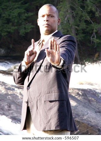 Business man with hands held out in front of him signifying stop or halt