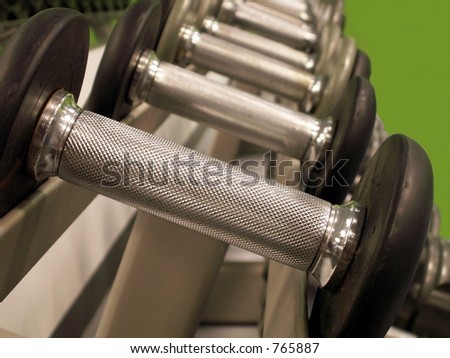Row of bar bells in varying weights lined up in a row.