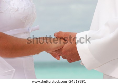 A U.S. Navy sailor and his bride hold hands at their wedding on the beach in Hawaii.