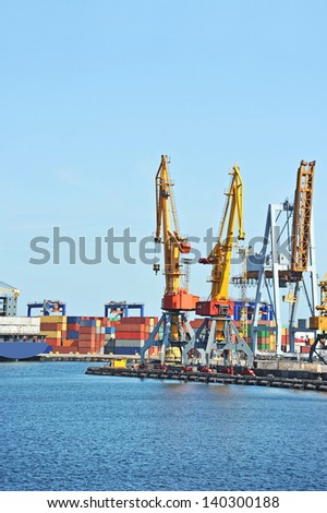 Port cargo crane, container and ship over blue sky background