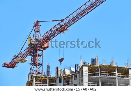 Building crane and building under construction against blue sky Building crane and building under construction against blue sky