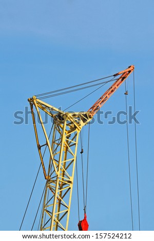 Mobile yellow construction tower crane against blue sky