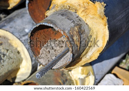 Rusty steel pipe with heat insulation on construction site