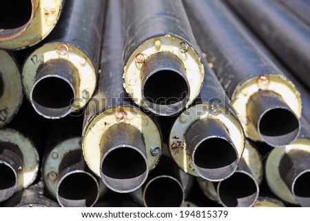Rusty steel pipe with heat insulation on construction site