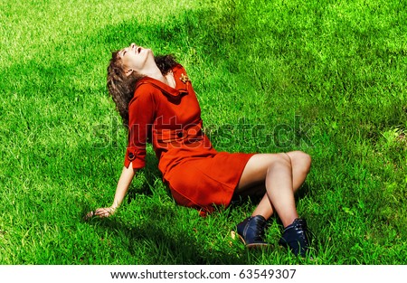 happy girl laughs loudly on grass, having thrown back head