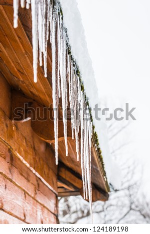 roof of the house with snow and icicles hanging