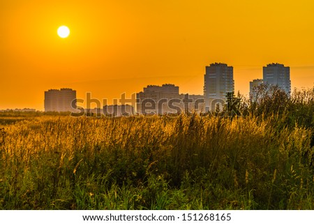 city Ã?Â¢??Ã?Â¢??on the background of the rising sun orange