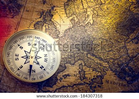 compass and magnifying glass gold color on the old map with coins