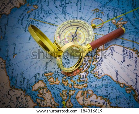 compass and magnifying glass lie on the topographic map