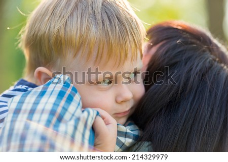 middle-aged brunette woman holding her grandson in her arms