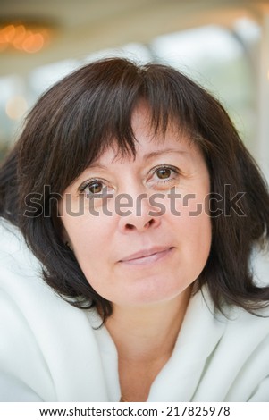 portrait of a middle-aged woman dark hair brown eyes is sitting in the apartment