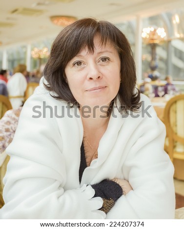 portrait of a middle-aged woman dark hair brown eyes is sitting in the apartment