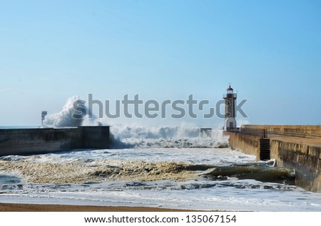 Strong waves hitting the breakwaters and the lighthouses