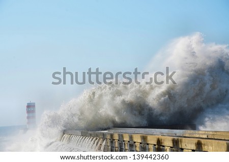 Strong waves hitting the breakwater and the lighthouse