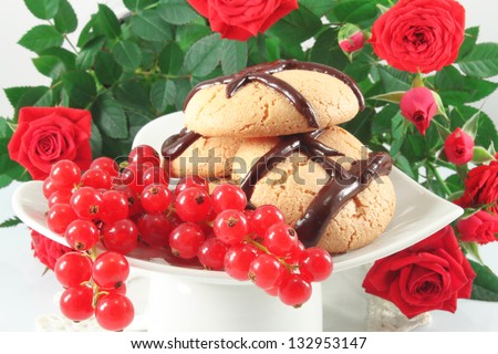 Cookies with chocolate and red currant, still life with roses