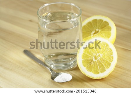 A glass of water, lemon, soda bicarbonate