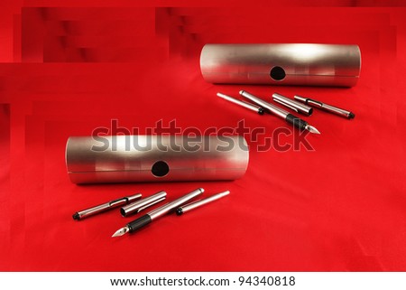 A set of writing pens on a red background
