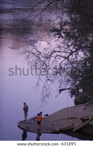 Some people enjoying the evening fishing by the river.