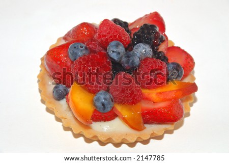 fruit tart with creme strawberries blueberries and other fruit isolated on a black plate