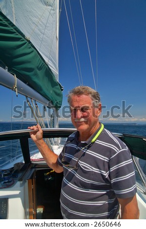 A retired man on his sailboat posing for a photo