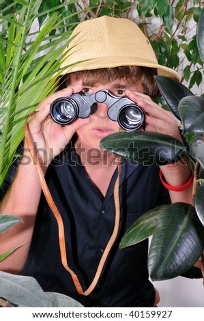 young man exploring the jungle with a pair of binoculars