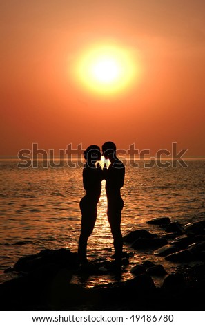 The loving couple on a decline, the sea, shines the sun